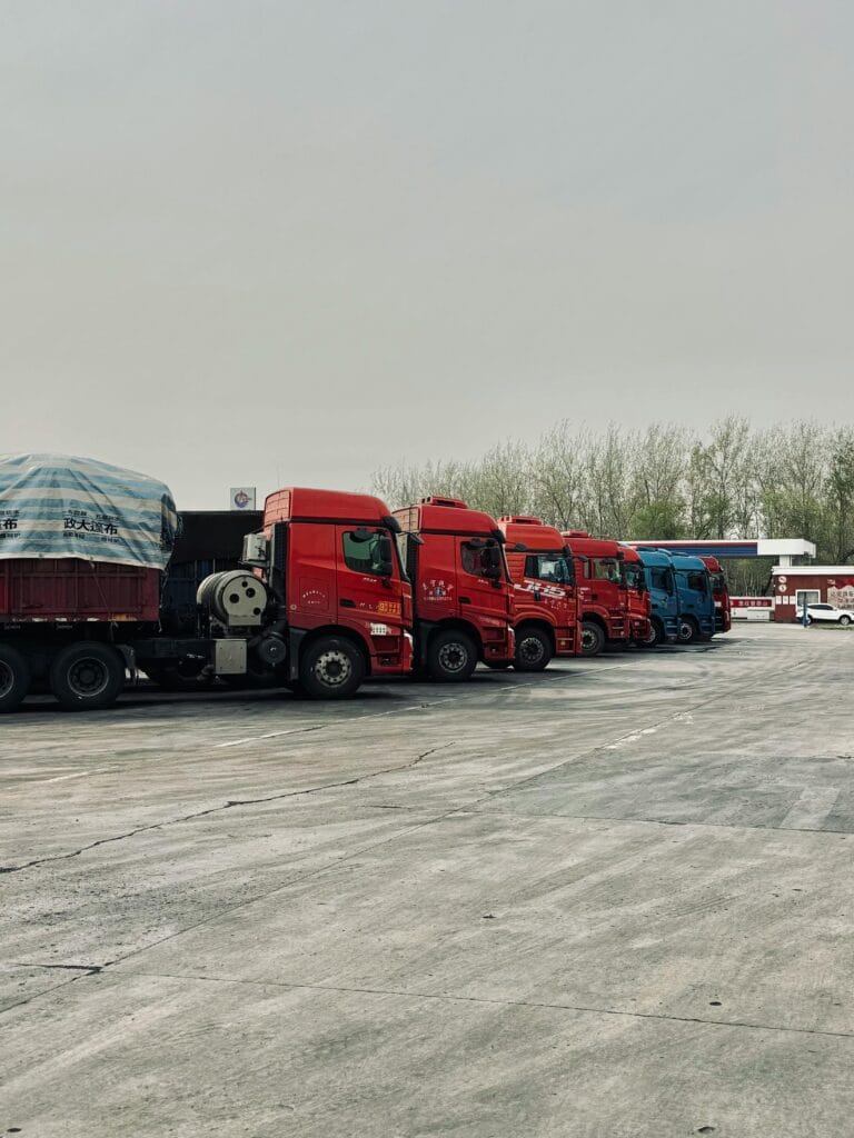 pexels-photo-20882742-20882742 Line of red trucks parked outdoors in Tianjin, China, showcasing transportation logistics.